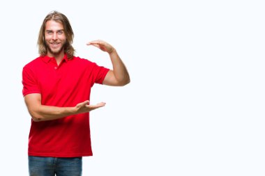 Yakışıklı delikanlı ile büyük ve büyük boy işaret, ölçü birimi sembol gösteren el eller izole arka plan üzerinde uzun saçlı. Kameraya bakarak gülümsüyordu. Ölçüm kavramı.