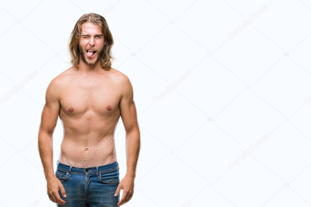 Young handsome shirtless man with long hair showing sexy body over isolated background sticking tongue out happy with funny expression. Emotion concept.