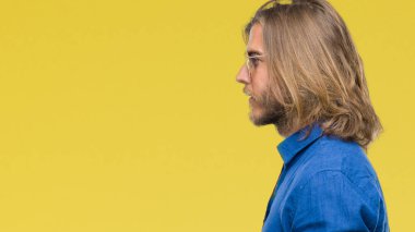 İzole arka tarafına, seyir üzerinde güneş gözlüğü takmış uzun saçlı Genç yakışıklı adam sakin ol kendine güvenen gülümseme ile doğal yüz pozuyla profili.