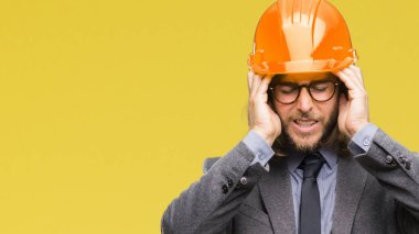 Çünkü çaresiz ve stresli baş ağrısı acı izole arka plan üzerinde güvenlik kask giymiş uzun saçlı Genç yakışıklı architec adam ağrı ve migren. Ellerini kafasına.