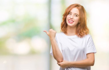 Seyir ve başparmak yanında yukarıyı mutlu yüz ile gülümseyen izole arka plan üzerinde genç güzel kadın.