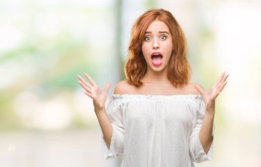 Genç güzel kadın deli kutluyor ve silah ile başarı için heyecanlı çığlık kaldırdı ve açık gözleri hayret izole arka plan yüzünden. Kazanan kavramı