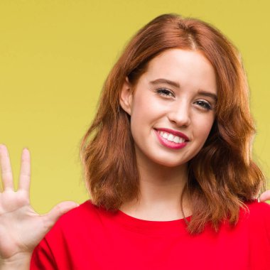 Genç güzel kadın gösterilen ve parmakları ile işaret izole arka plan yüzünden kendinden emin ve mutlu gülümseyerek süre on numara.