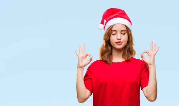 年轻美丽的女人在孤立的背景下戴着圣诞帽放松和微笑闭上眼睛做冥想手势用手指 瑜伽理念 — 图库照片