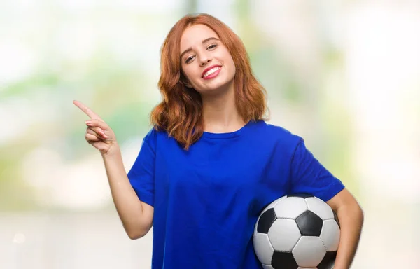 Молодая Красивая Женщина Изолированном Фоне Держа Футбольный Мяч Счастливо Указывая — стоковое фото