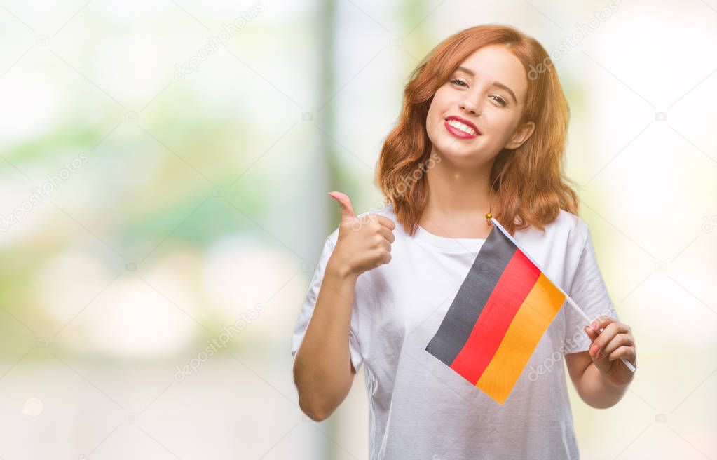 Young beautiful woman holding flag of germany over isolated background happy with big smile doing ok sign, thumb up with fingers, excellent sign