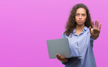 Bilgisayar dizüstü açık eliyle dur işareti ile ciddi ve kendine güvenen ifade, savunma jest yapıyor tutan genç İspanyol kadın