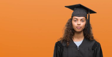 Ciddi düşünme akıllı yüzünde mezuniyet kendine güvenen bir ifade ile üniforma giyen genç İspanyol kadın