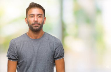 Yüzünde ciddi bir ifade ile izole arka plan yetişkin İspanyol adam. Basit ve doğal kameraya bakıyor.