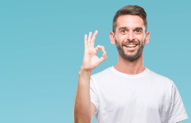 Gülümseyen izole arka plan üzerinde genç yakışıklı adam el ve parmaklar ok işaretiyle yapıyor olumlu. Başarılı ifade.