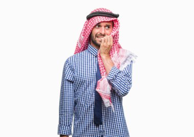 Stresli ve gergin elle çivi ısırma ağzına bakarak izole arka plan üzerinde keffiyeh giyen genç yakışıklı Arap iş adam. Anksiyete sorunu.
