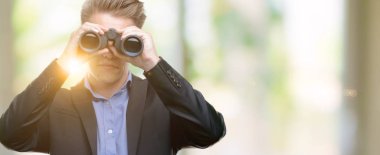 Genç yakışıklı sarışın adam akıllı yüz ciddi düşünüyorum üstünde kendine güvenen bir ifade ile dürbün üzerinden seyir