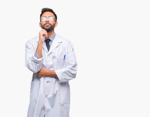 成年西班牙裔科学家或医生穿白色大衣在孤立的背景下与手在下巴思考问题 沉思的表达 微笑与周到的脸 怀疑概念 — 图库照片
