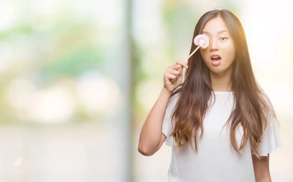 배경에 놀라운 두려워 식으로 충격에서 롤리팝 사탕을 아시아 — 스톡 사진