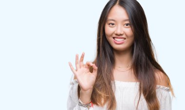 Gülümseyen izole arka plan üzerinde Genç Asyalı kadın el ve parmaklar ok işaretiyle yapıyor olumlu. Başarılı ifade.