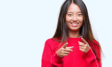 Genç Asyalı kadın kamera ile mutlu ve komik yüz için parmakları işaret izole arka plan üzerinde kış kazak giyiyor. İyi enerji ve vibes.