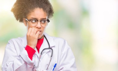 Genç afro Amerikalı doktor kadın yüzünden stresli ve gergin elle çivi ısırma ağzına bakarak izole arka plan. Anksiyete sorunu.