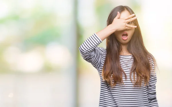 年轻的亚洲妇女戴着眼镜在孤立的背景下偷看脸和眼睛用手 看着通过手指尴尬的表情 — 图库照片