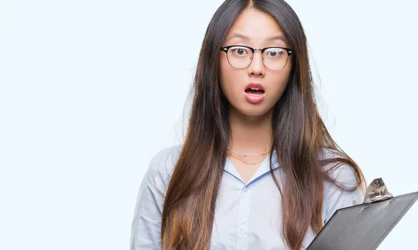 Joven Mujer Negocios Asiática Sosteniendo Portapapeles Sobre Fondo Aislado Asustada —  Fotos de Stock