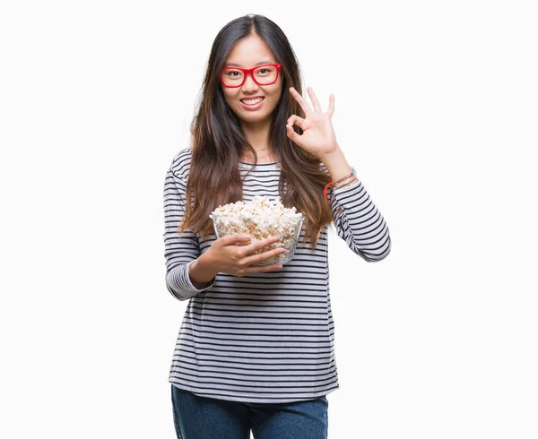Молода Азіатська Жінка Їсть Попкорн Над Ізольованим Тлом Робить Знак — стокове фото
