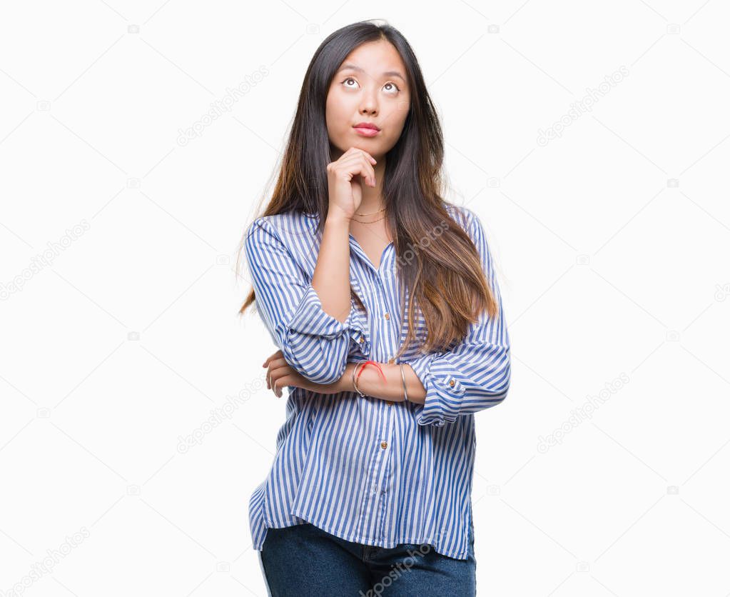 Young asian woman over isolated background with hand on chin thinking about question, pensive expression. Smiling with thoughtful face. Doubt concept.