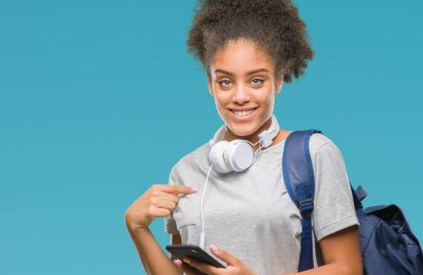 Sırt çantası sürpriz yüz işaret parmağı kendini izole arka plan üzerinde tutan genç güzel afro Amerikan öğrenci kadın