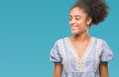 Uzak tarafına yüzünde, doğal ifade gülümseme ile seyir izole arka plan üzerinde genç afro Amerikalı kadın. Kendine güvenen gülüyor.