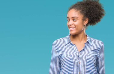 Uzak tarafına yüzünde, doğal ifade gülümseme ile seyir izole arka plan üzerinde genç afro Amerikalı kadın. Kendine güvenen gülüyor.