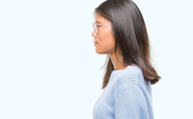 Genç Asyalı kadın giyiyor kış kazak izole arka tarafına, seyir üzerinde dinlenmek doğal yüz emin gülümseme ile pozuyla profili.