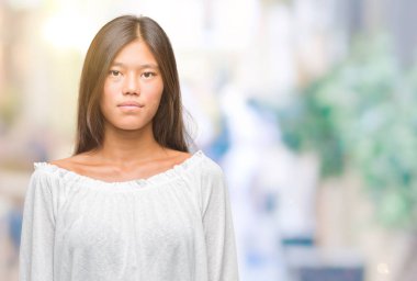 Genç Asyalı kadın yüzünde ciddi bir ifade ile izole arka plan üzerinde. Basit ve doğal kameraya bakıyor.