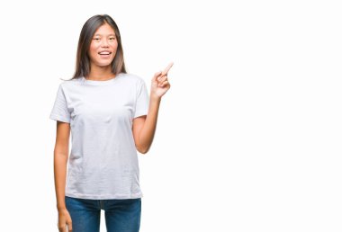 Kameraya bakarak yan el ve parmak ile işaret eden Genç Asyalı kadın yüzünde kocaman bir gülümseme ile izole arka plan üzerinde.