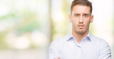 Yakışıklı genç işadamı şüpheci ve sinir, onaylamayan ifade yüz çapraz kolları üzerinde. Negatif kişi.