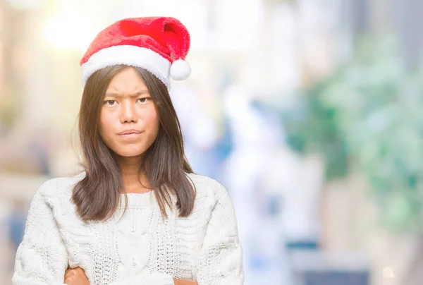 年轻的亚洲妇女戴着圣诞帽在孤立的背景怀疑和紧张 不赞成的表情与交叉的武器 消极的人 — 图库照片