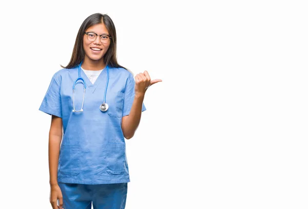 探していると親指側に上向きの幸せそうな顔を浮かべて孤立の背景の上の若いアジア医師女性 — ストック写真