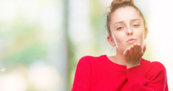 Young Blonde Woman Wearing Bun Red Sweater Looking Camera Blowing — Stock Photo, Image