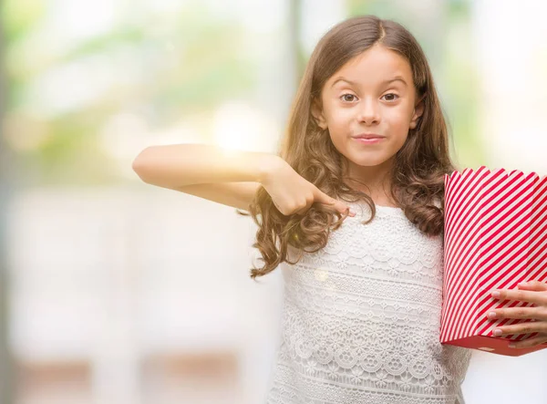 自分自身に驚き顔人差し指でポップコーンを食べるブルネットのヒスパニック系の女の子 — ストック写真