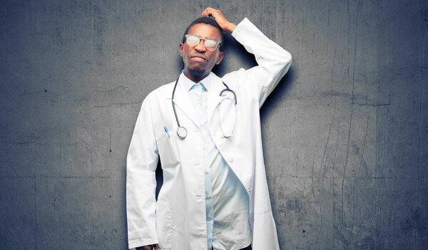 Young black doctor, medical professional doubt expression, confuse and wonder concept, uncertain future