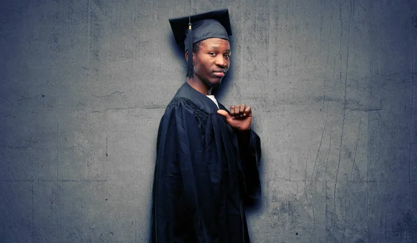 Młody Absolwent Afryki Czarny Człowiek Dumny Podekscytowany Arogancki Wskazując Twarzy — Zdjęcie stockowe