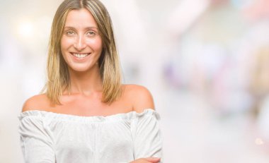 İzole arka plan mutlu yüz çapraz silah kameraya bakarak ile gülümseyen genç güzel kadın. Olumlu bir kişi.