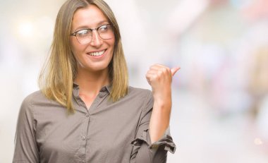 Seyir ve başparmak yanında yukarıyı mutlu yüz ile gülümseyen izole arka plan üzerinde genç güzel kadın.