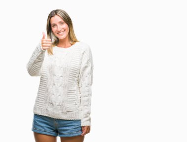 Hareketi el ile mutlu yaşasın yapıyor izole arka plan üzerinde kış kazak giyen genç güzel kadın. Kameraya bakarak başarı gösteren ile ifade onaylama.