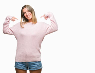 Yüzünde gülümseme ile kendinden emin görünüyorsun, kendini gururlu ve mutlu parmakları ile işaret izole arka plan üzerinde kış kazak giyen genç güzel kadın.