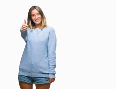 Hareketi el ile mutlu yaşasın yapıyor izole arka plan üzerinde kış kazak giyen genç güzel kadın. Kameraya bakarak başarı gösteren ile ifade onaylama.