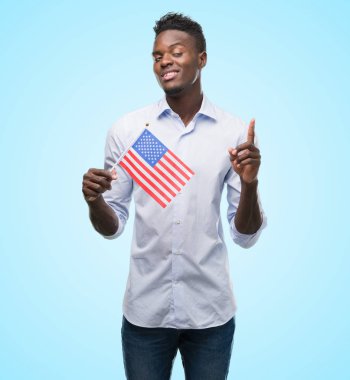 ABD bayrağı sürpriz bir fikir ya da soru işaret parmağı ile gülen yüz, bir numara tutan genç Afro-Amerikan adam