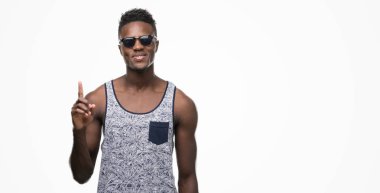 Genç Afro-Amerikan adam bir fikir ya da soru işaret parmağı gülen yüz, bir numara ile sürpriz