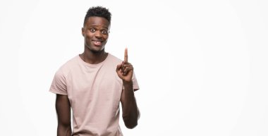 Genç Afro-Amerikan adam bir fikir ya da soru işaret parmağı gülen yüz, bir numara ile sürpriz