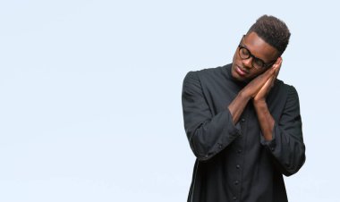 Uyku yorgun hayal ve ellerle birlikte poz ile kapalı gözler gülümseyen izole arka plan genç Afro-Amerikan rahip adam.