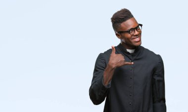 Genç Afro-Amerikan rahip adam yapıyor gülümseyen izole arka plan üzerinde telefon hareketi ile el ve parmak telefonda konuşuyor gibi. Kavramları iletişim.