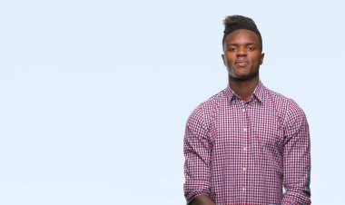 Afrikalı-Amerikalı genç yüzünde ciddi bir ifade ile izole arka plan üzerinde. Basit ve doğal kameraya bakıyor.