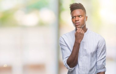 Afrikalı-Amerikalı genç çene düşünme hakkında soru, dalgın ifade üzerine el ile izole arka plan üzerinde. Düşünceli yüzüyle gülümsüyor. Şüphe kavramı.